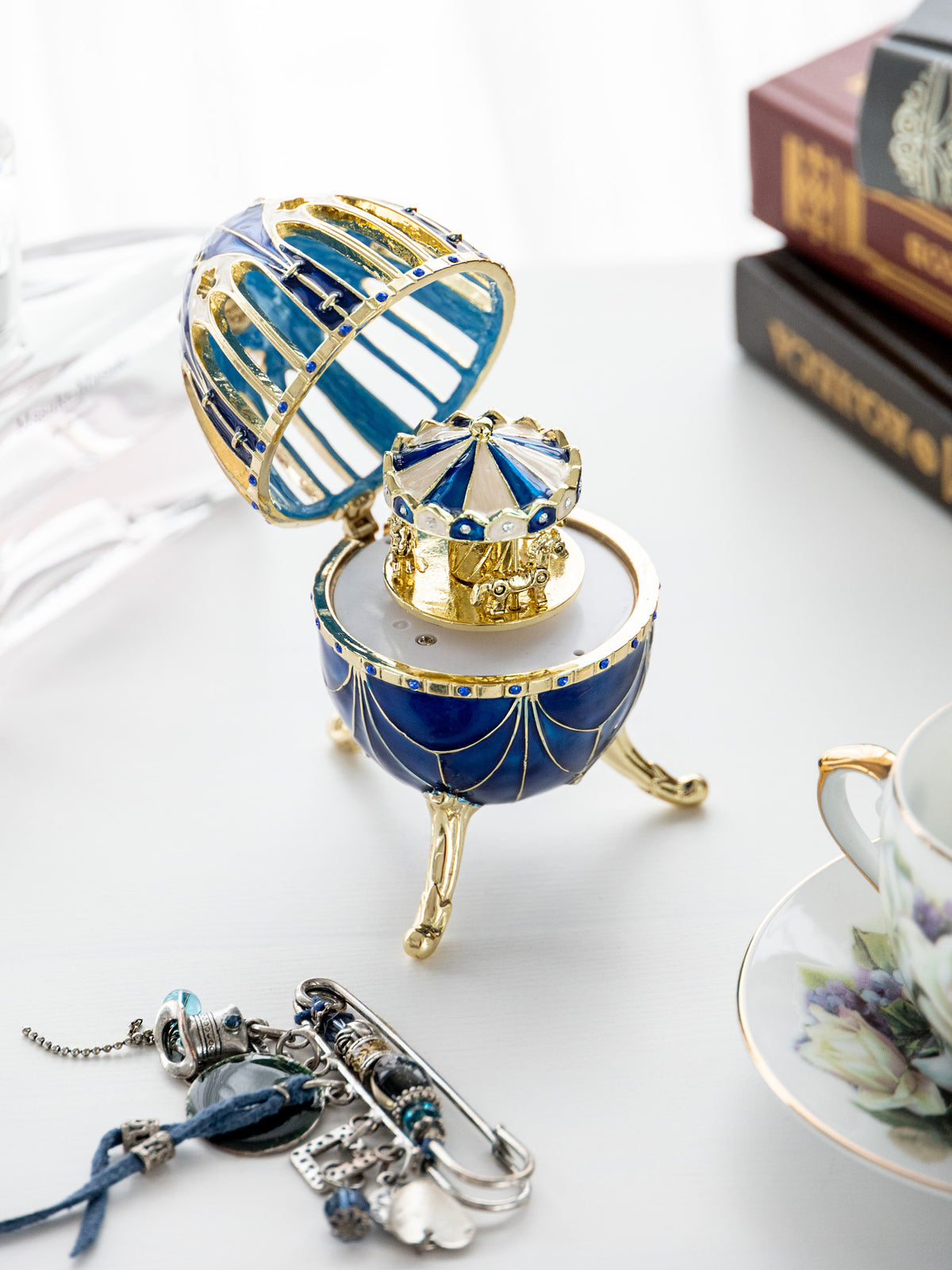 Oeuf Fabergé bleu et or avec surprise de carrousel à chevaux à l'intérieur