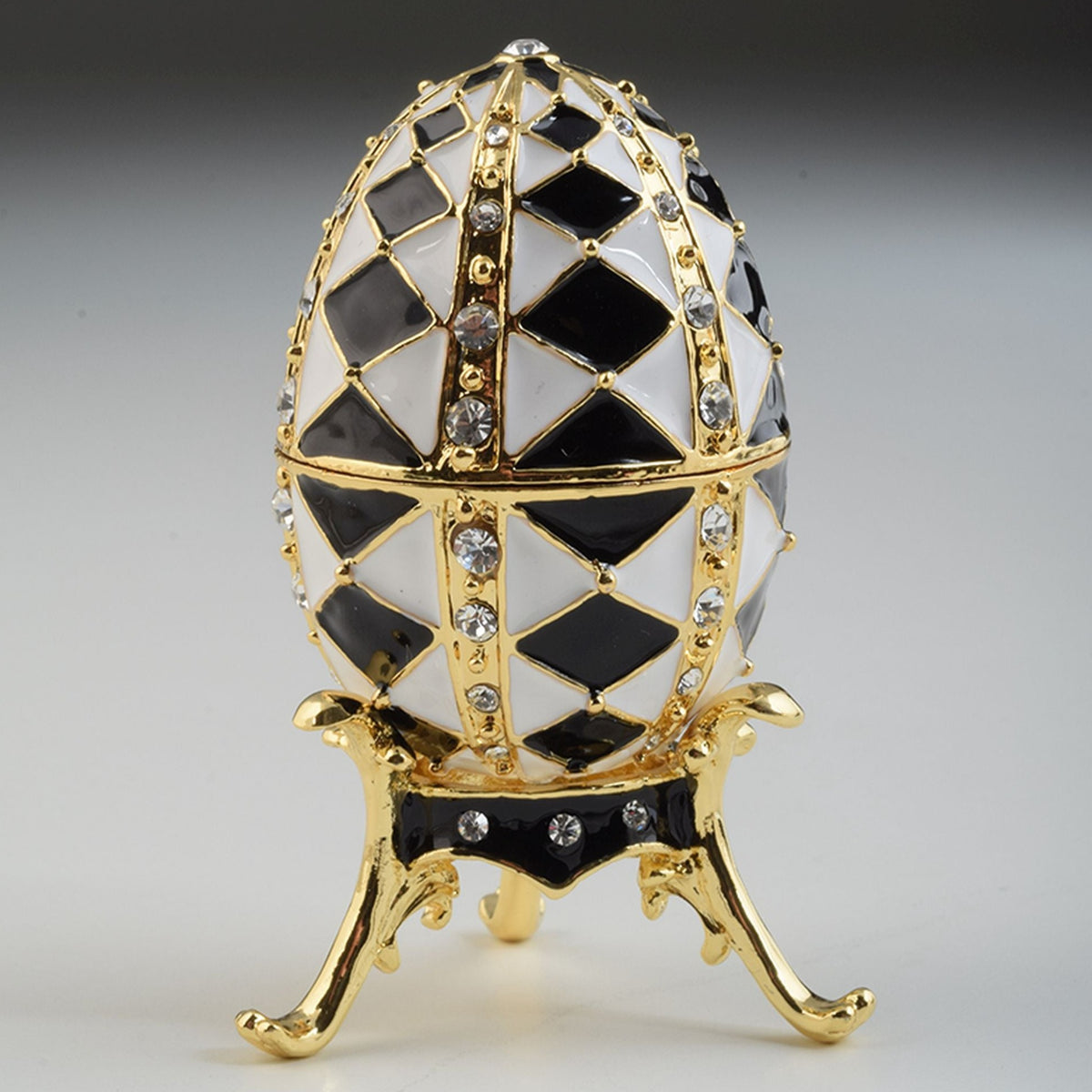 Schwarz-weißes Fabergé-Ei mit goldener Halskette im Inneren